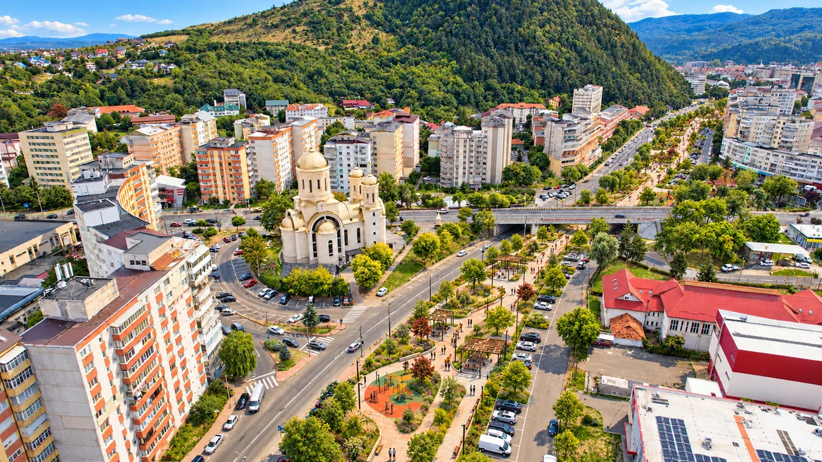 Simulare conceptuală a albiei Cuiejdiului din Piatra-Neamț, acoperită cu spații de recreere, zone verzi și parcări, într-o zi însorită.