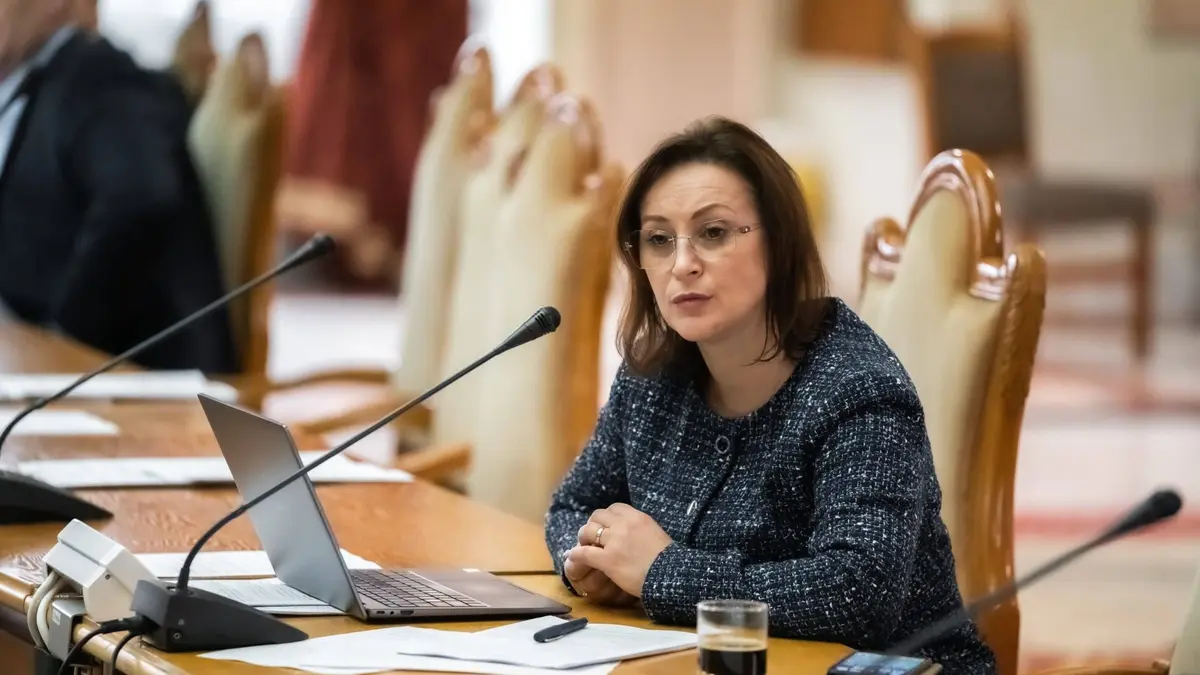 Dumitrina Mitrea, deputată AUR de Neamț, la o masă de ședință cu microfon și laptop