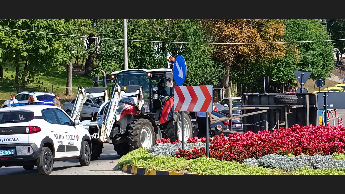 Tractor și remorcă răsturnată în sensul giratoriu din fața spitalului din Piatra-Neamț.